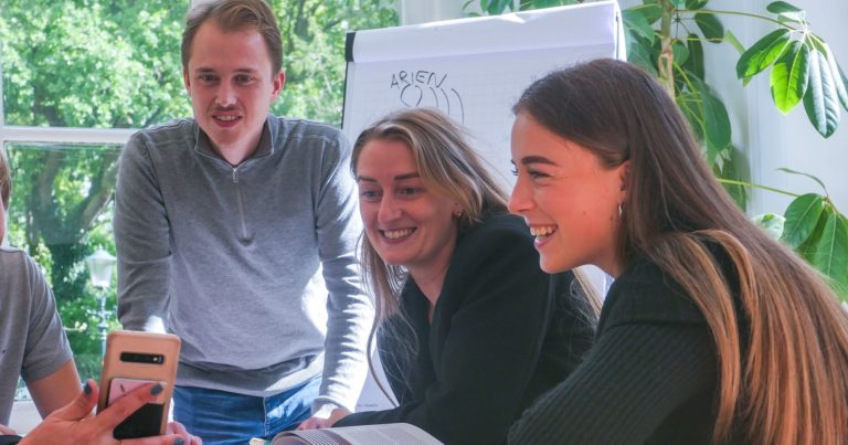 Medewerkers van In2Talent die aan het lachen zijn naar een telefoon